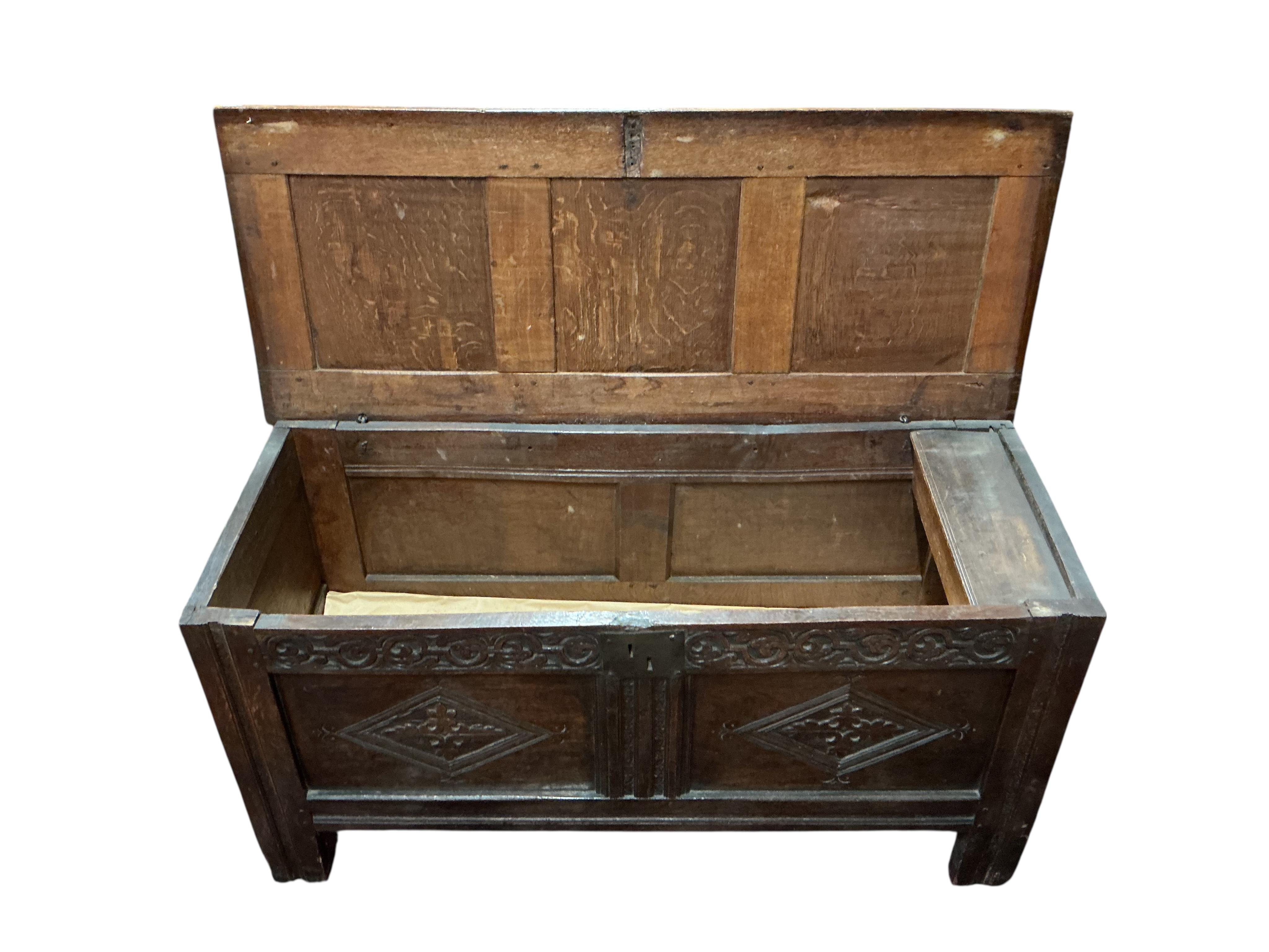 A 17th century oak coffer, the panelled front carved with lozenges, width 126cm, depth 51cm, height 64cm